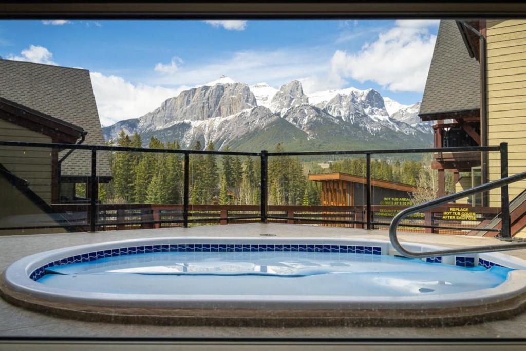 Serene 3BR Rockies Stay with Hot Tub and Near DT في كانمور: حوض استحمام ساخن على شرفة مطلة على الجبال