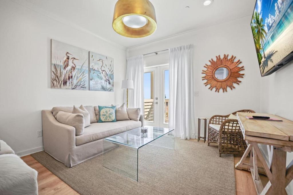 a living room with a couch and a glass table at Beach Access Condo-Walk to Downtown-Pets Welcome w/ Fee in Pass Christian