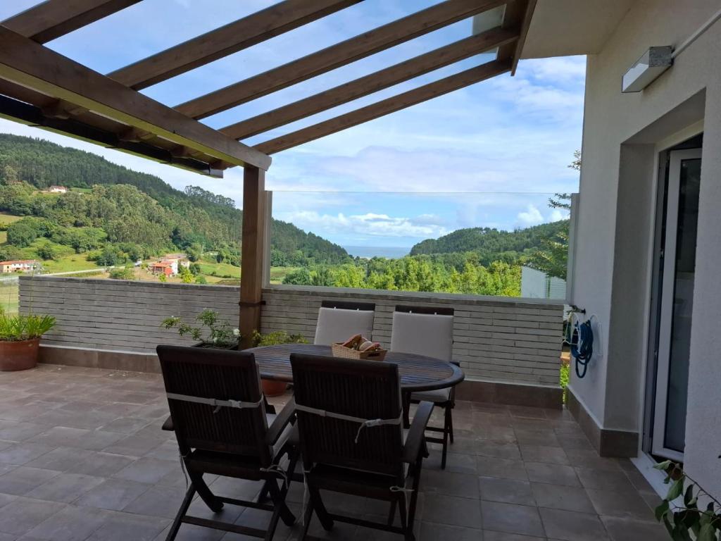 a patio with a table and chairs and a view at La Pabla in Colunga