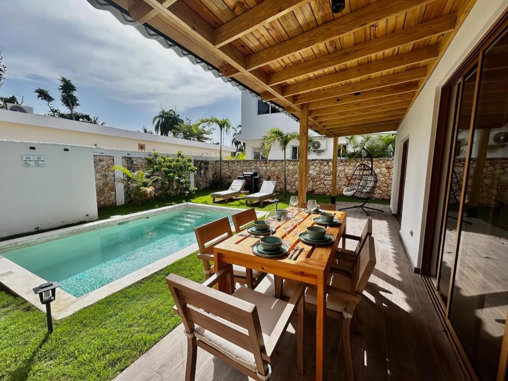 a patio with a table and chairs next to a swimming pool at Villa Palmera in Las Terrenas