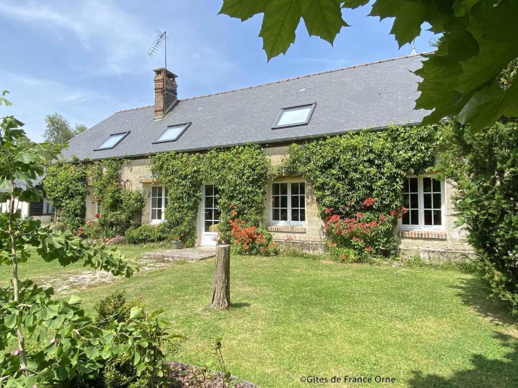 an old stone house with windows and ivy at Longère spacieuse avec jardin à Saint-Evroult, animaux admis sur demande - FR-1-497-257 in Touquettes