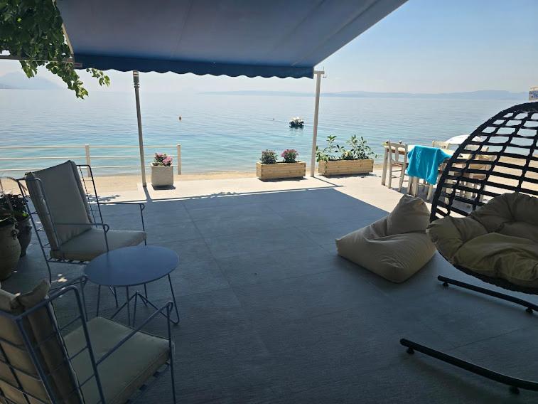 a patio with chairs and a table and the ocean at Ilia Suites ''Paralia'' in Ilia