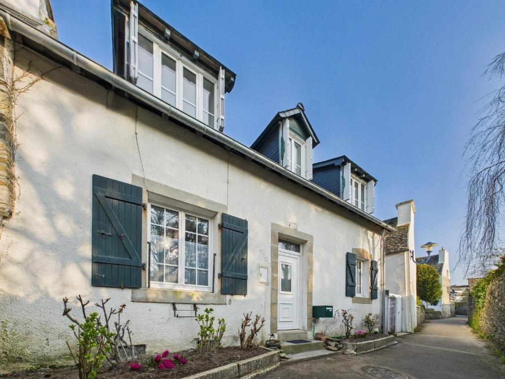 a white house with black shuttered windows at Loki Rivoli Cottage in Locquirec
