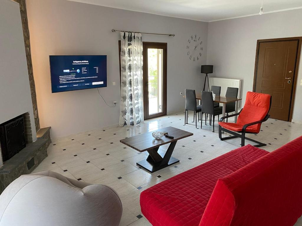 un soggiorno con un divano rosso e un tavolo di Whole house Stropones Evia a Strópones