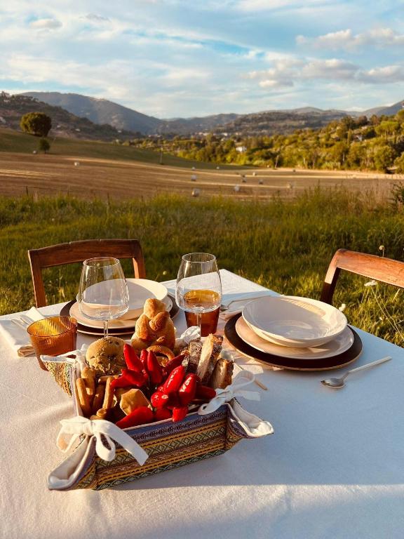 a picnic table with a basket of food and glasses of wine at Villa FARFA in Castelnuovo di Farfa