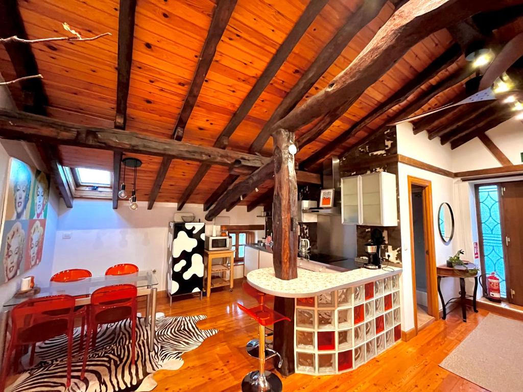une cuisine avec des plafonds en bois et un tapis zébré dans l'établissement BILBO Near ático rural con terraza, à Basauri