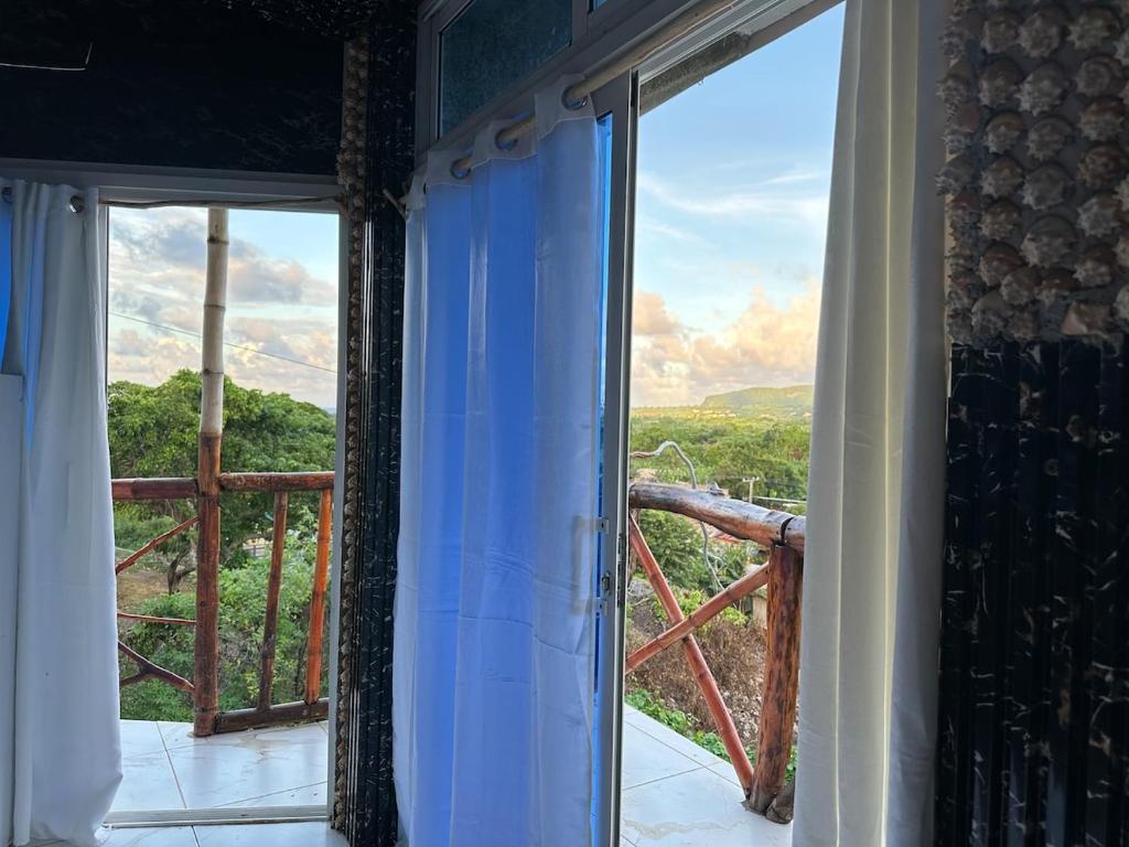 d'une chambre avec une porte coulissante en verre offrant une vue. dans l'établissement Guest House vista al mar Las Galeras 1, à Las Galeras