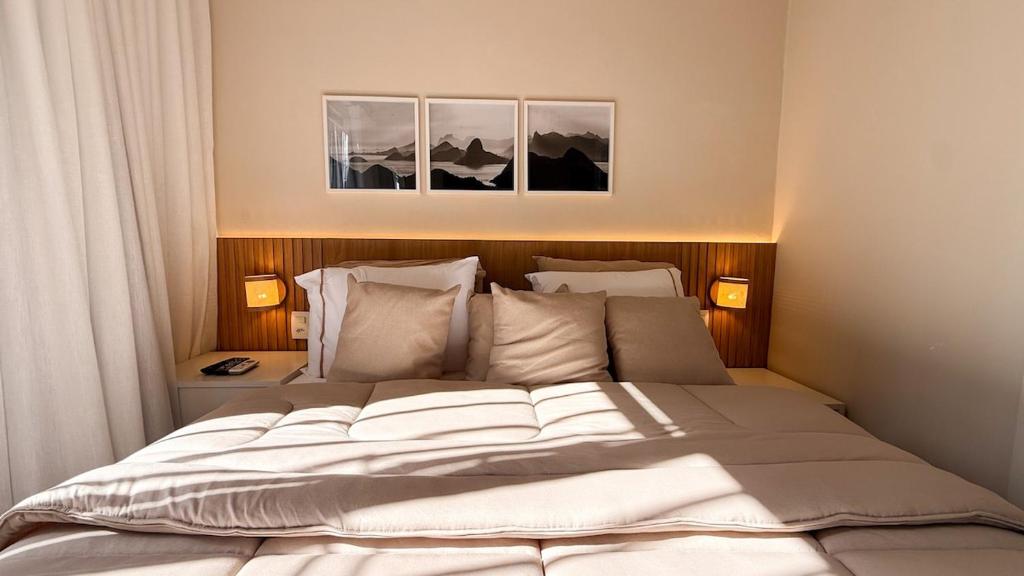 a bedroom with a large bed with two lamps at Studio Quarto e Sala Moderno em Ipanema, próximo a praia in Rio de Janeiro