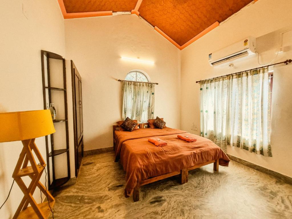 a bedroom with a bed in a room with a window at Kulture KonnectT Kurakanni in Varkala