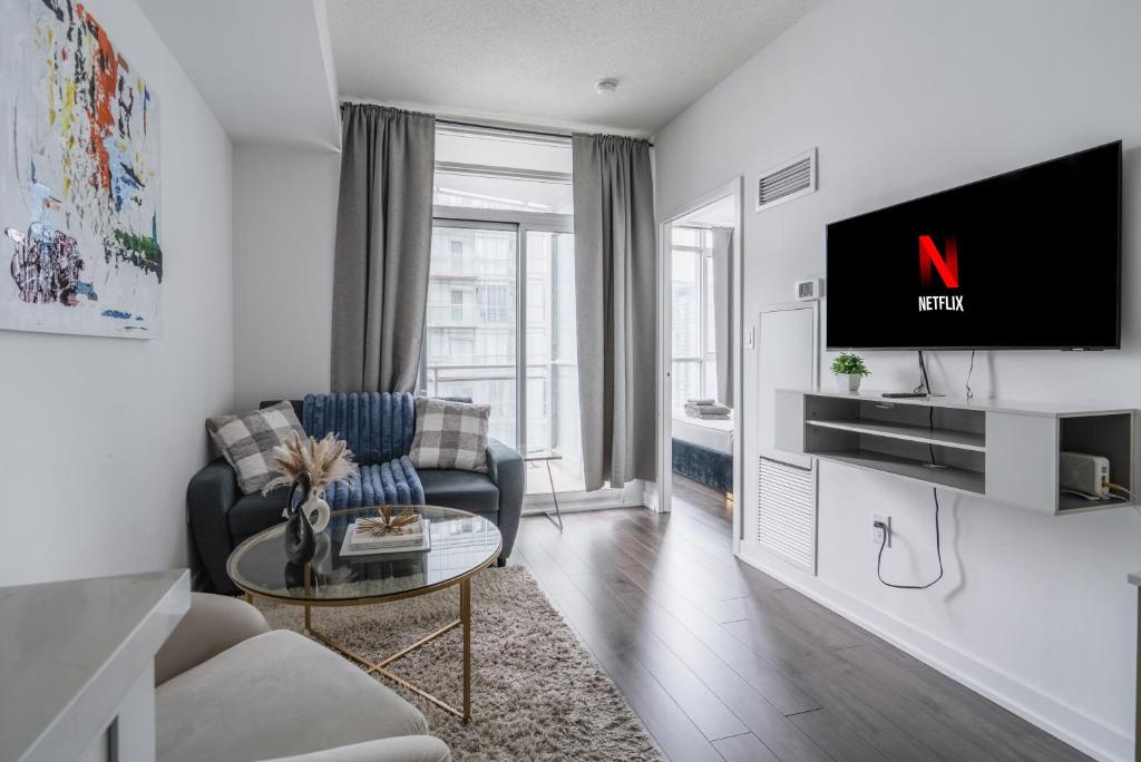 a living room with a couch and a tv on a wall at Downtown Toronto luxury condos in Toronto