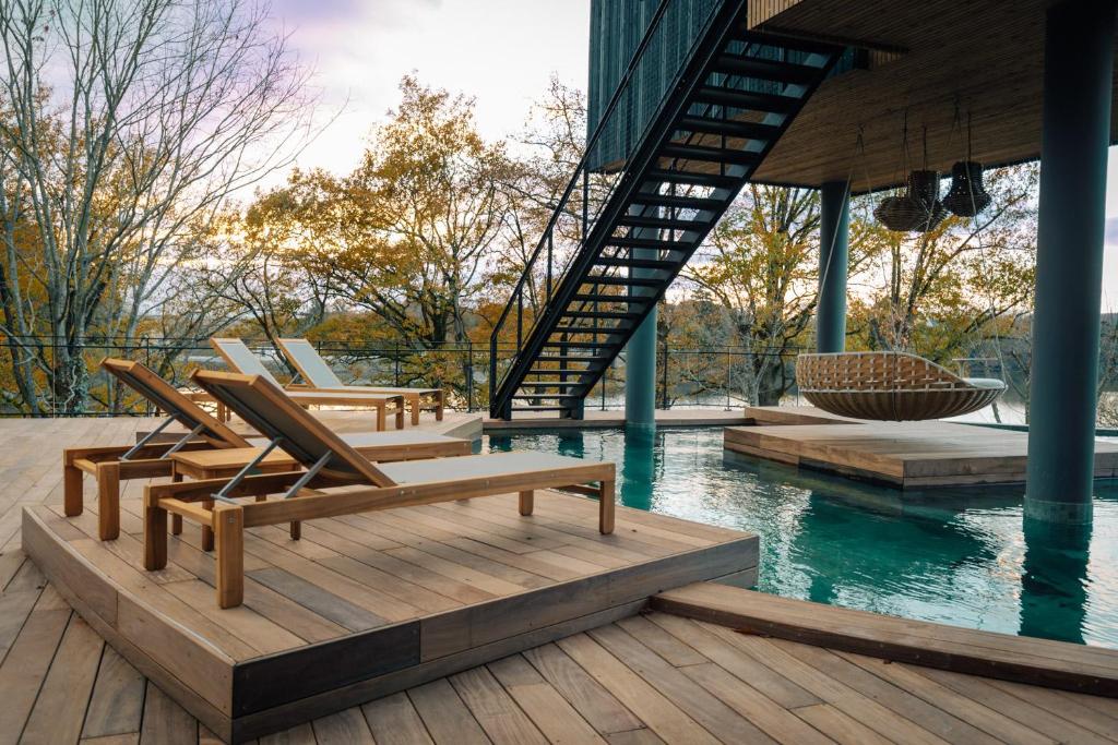 a group of chairs sitting on a deck next to a pool at Best Western Plus Le Roi Arthur Hôtel & Spa in Ploërmel
