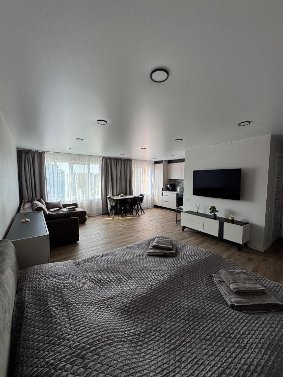 a large living room with a large bed and a television at JK apartment in Rēzekne
