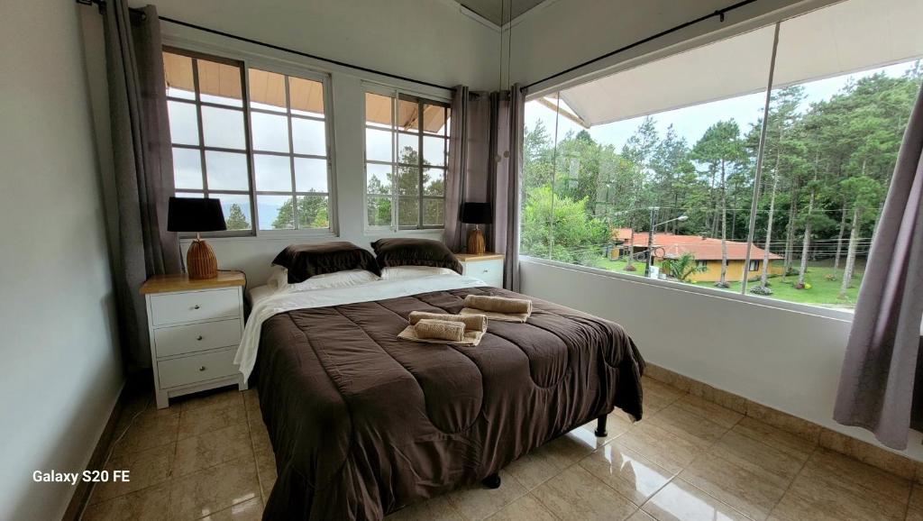 una camera da letto con un letto e una grande finestra di Villa Paraiso de Montana en Altos del Maria a Sorá