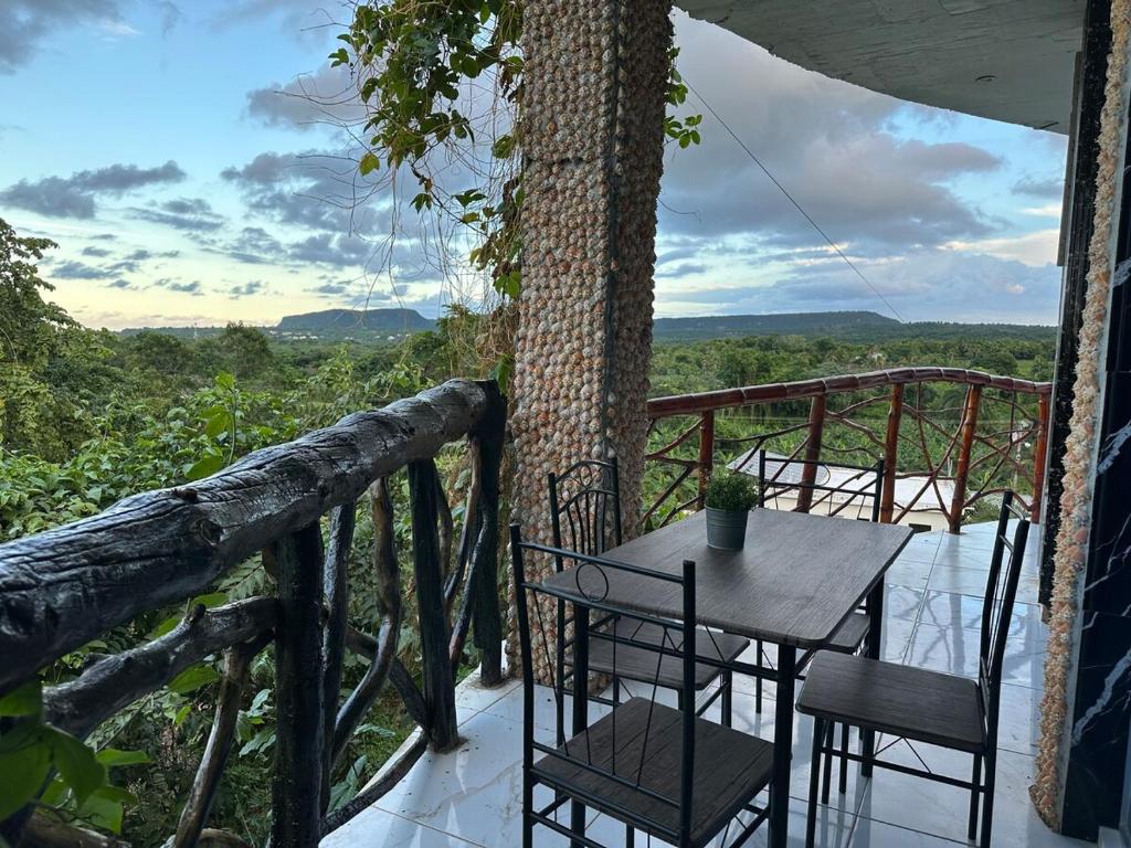 a table and chairs on a balcony with a tree at Guest-House ocean view in Las Galeras 2 in Las Galeras