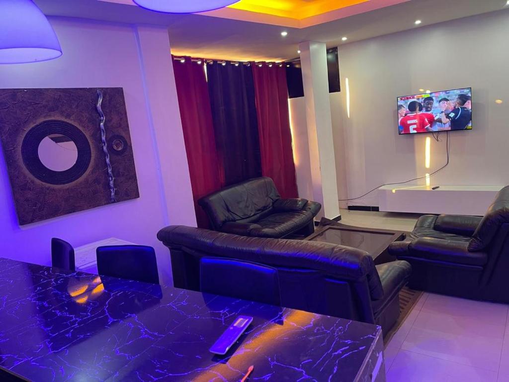 a living room with a couch and chairs and a tv at Yoff Apixi 2 in Dakar
