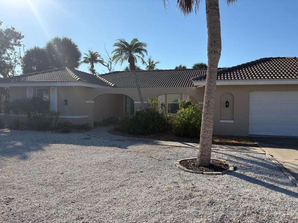 een huis met een palmboom op de oprit bij Tranquil Tides in Sanibel Island