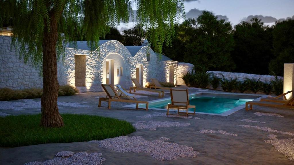 een huis met een zwembad en twee stoelen en een boom bij Borgo Pascarosa in Ostuni