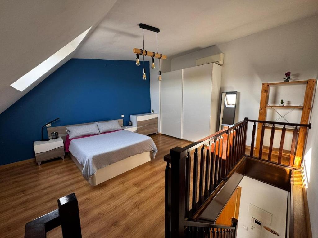 a bedroom with a bed and a blue wall at Cozy Apartment Madrid in Madrid