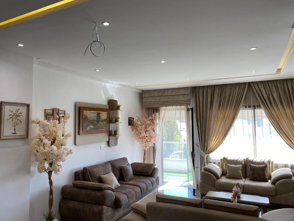 ein Wohnzimmer mit Sofas und einem großen Fenster in der Unterkunft Appartement coquet à Hammamet in Hammamet