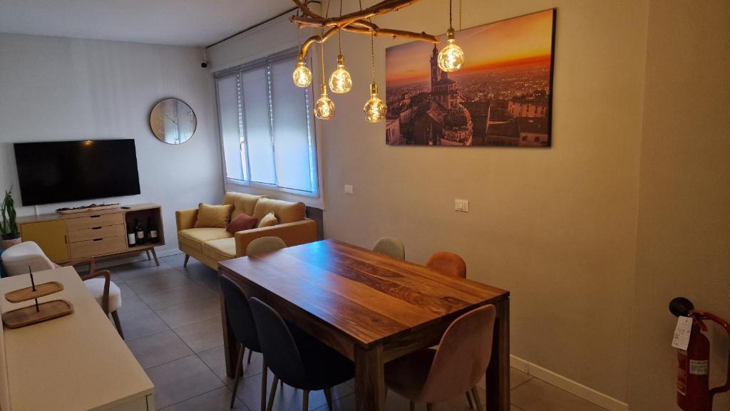 Una sala de estar con una mesa de madera y un sofá. en Nyx Lilura Seriate, en Seriate