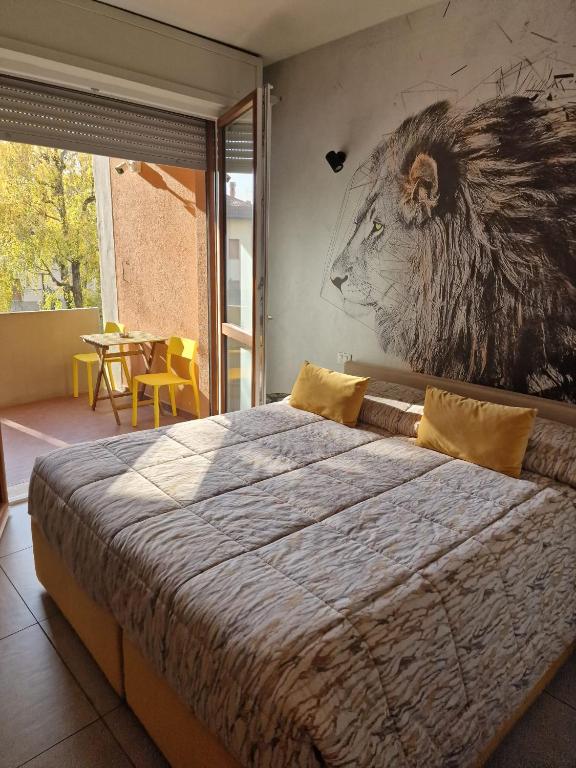 a bedroom with a large bed with a lion painting on the wall at Nyx Lilura Seriate in Seriate
