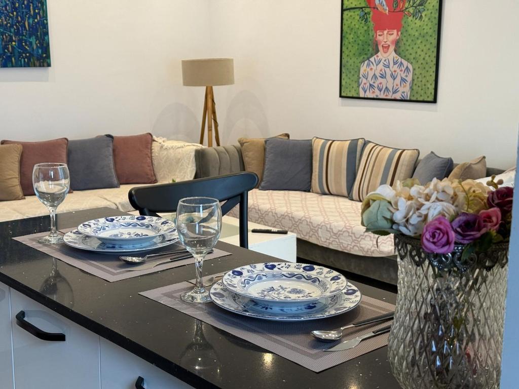 ein Wohnzimmer mit einem Tisch mit Tellern und Weingläsern in der Unterkunft Design, space and light in La Marsa in Dar Tahar Zaouch