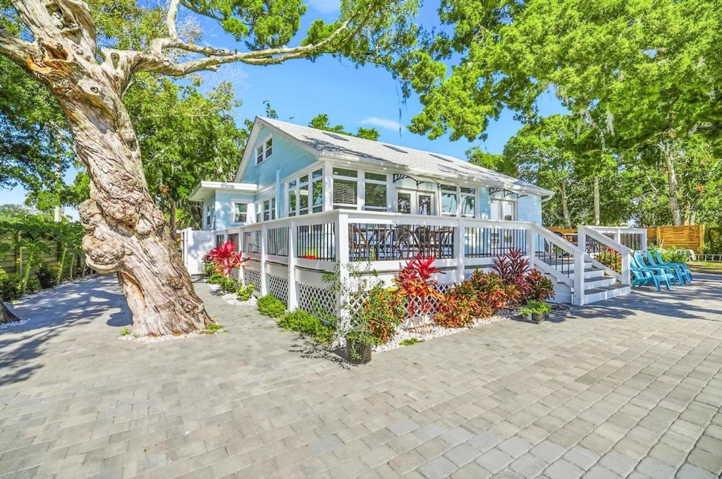 a white house with a tree in front of it at Waterfront Retreat Events Dock in St. Augustine