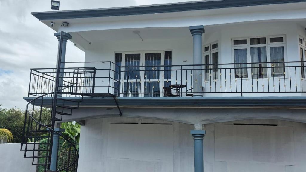 a balcony of a white house with a railing at Modern Villa near the Beach in Pereybere