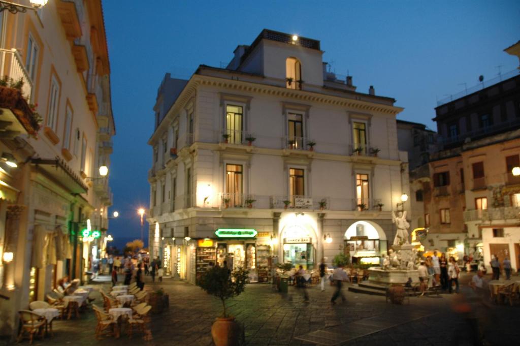 a building in a city with people walking around it at Hotel Fontana in Amalfi