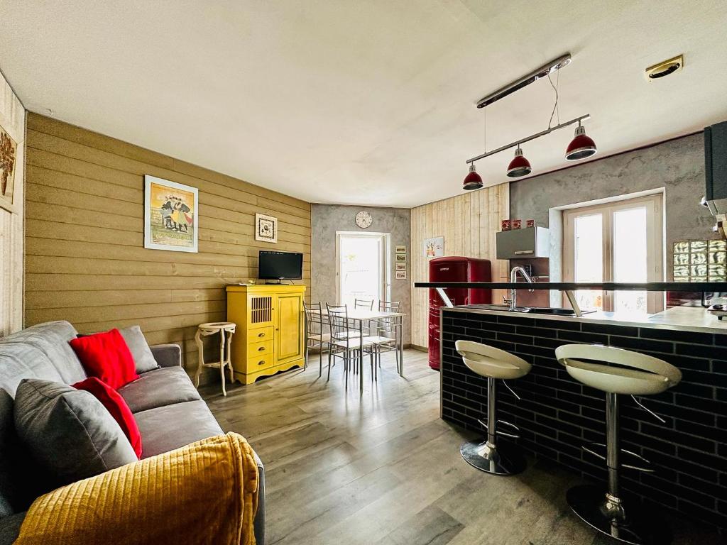 studio 2 personnes coeur de ville - proche plage في لي سابلِ دولونْ: غرفة معيشة مع أريكة ومطبخ