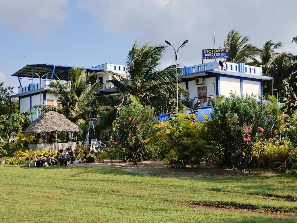Un gran edificio con césped delante. en Victory's Gardens, en Mannar