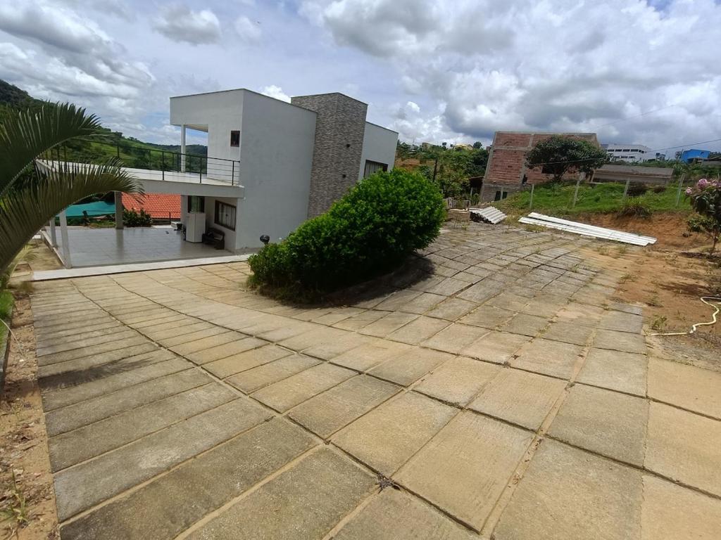 a house with a large patio in front of it at Chácara Aricanga in Aracruz