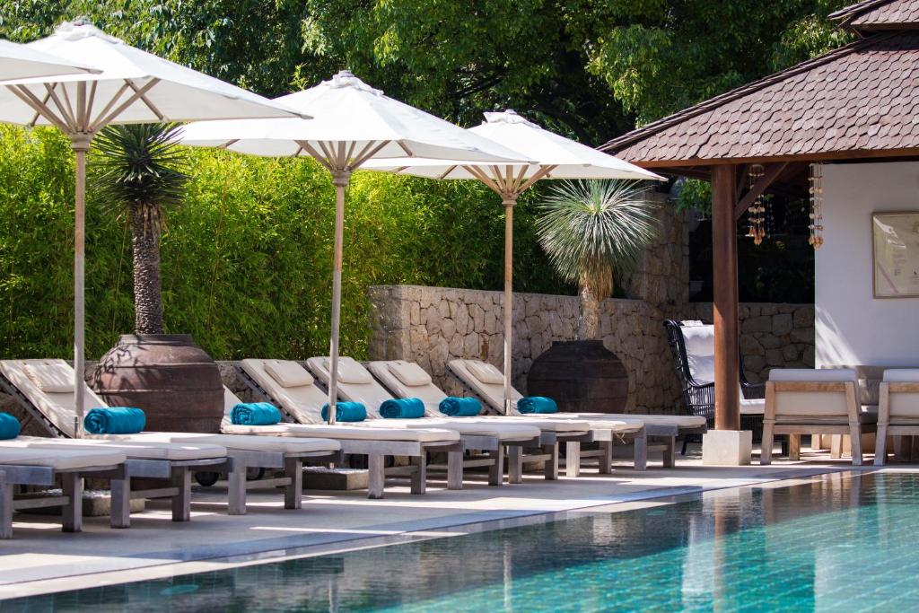 una piscina con sedie a sdraio e ombrelloni accanto a una piscina di Galboka Residence a Nerezine (Neresine)