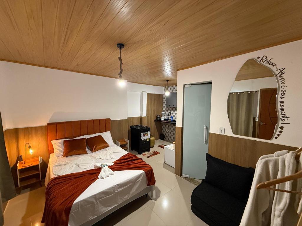 une chambre avec un lit et un miroir au mur dans l'établissement Flat Praia Grande, à Arraial do Cabo