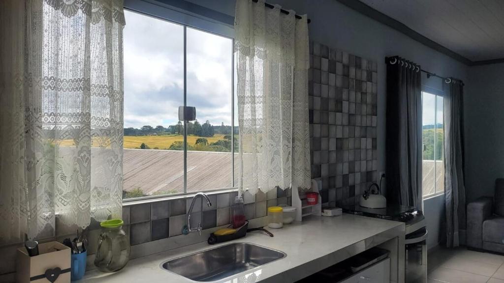 eine Küche mit einem Waschbecken und einem großen Fenster in der Unterkunft Yad elohai pousada israelense in Campo Alegre