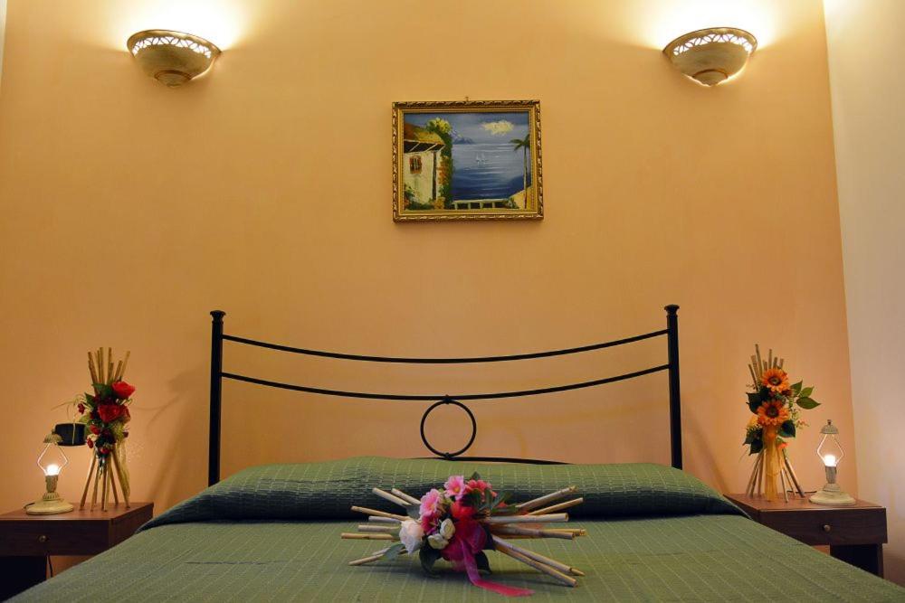 カルピニャーノ・サレンティーノにあるAgriturismo Molleのベッドルーム1室(花の装飾が施されたベッド1台付)