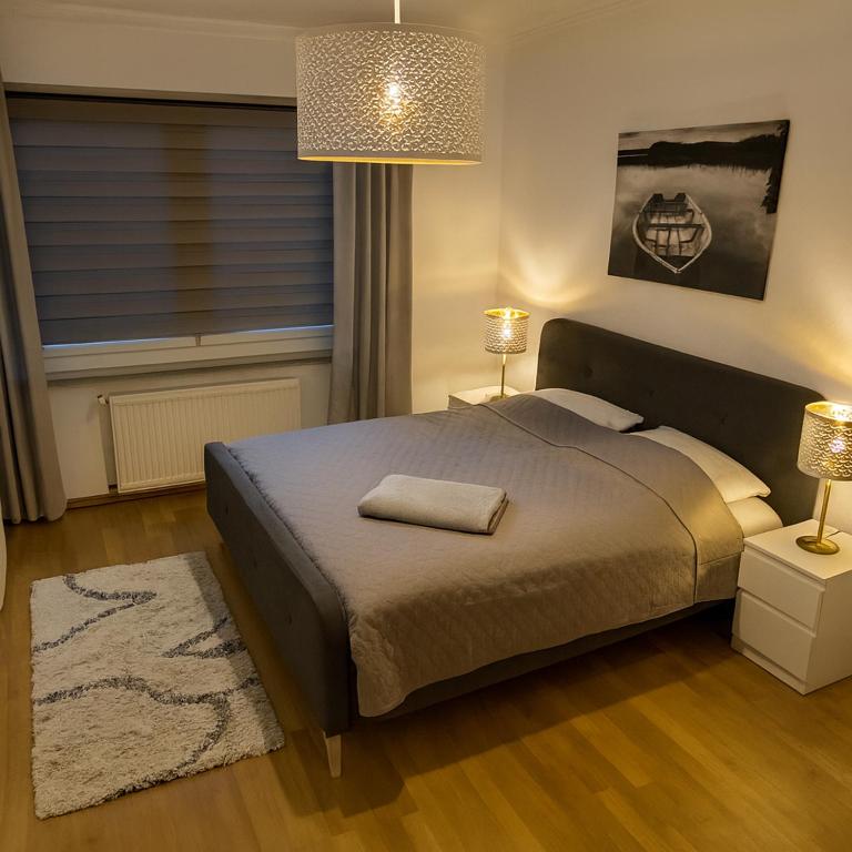 a bedroom with a bed with two lamps and a rug at Düsseldorf Apartment in Düsseldorf