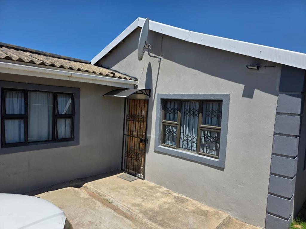 a white house with a door and two windows at Ngwanase Properties in Vosburg