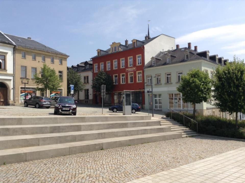 um grupo de edifícios e escadas numa cidade em Pension Eberhart em Treuen