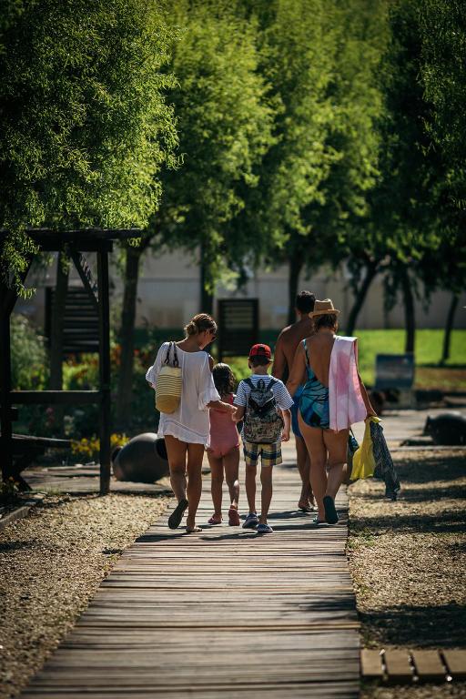 a group of people walking down a boardwalk at Green Life Apartments Sozopol in Sozopol