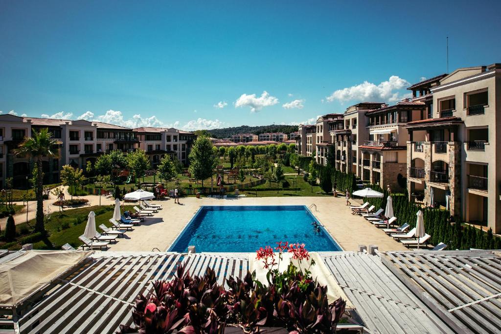 a view of a swimming pool with chairs and buildings at Green Life Apartments Sozopol in Sozopol