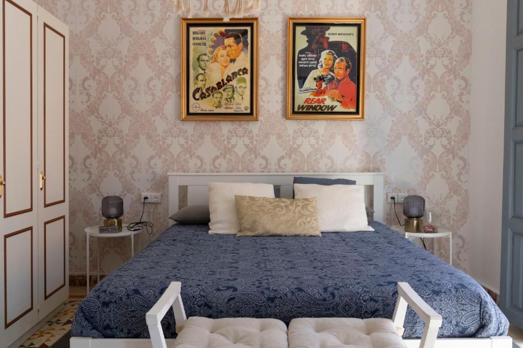 1 dormitorio con 1 cama con 2 posters en la pared en Caserón Centenario, en Cehegín