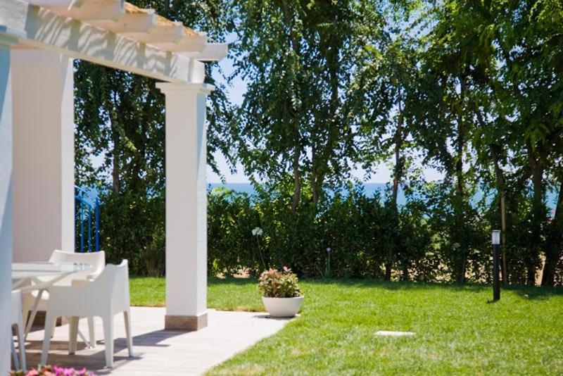 a white pergola with a table and chairs in a yard at Conero Infinito in Numana