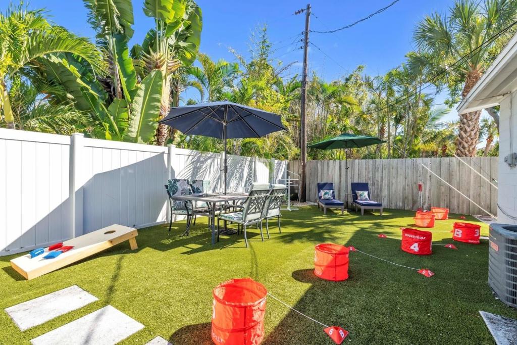 eine Terrasse mit Sonnenschirm und Tisch und Stühlen in der Unterkunft Barefoot Bungalow home in Anna Maria Island
