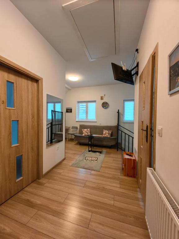 a hallway with a door and a living room at Apartamenty Starosądeckie in Stary Sącz