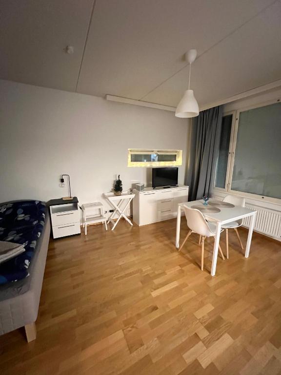 a living room with a bed and a table and chairs at Studio next to Sello and Leppävaara train station in Espoo