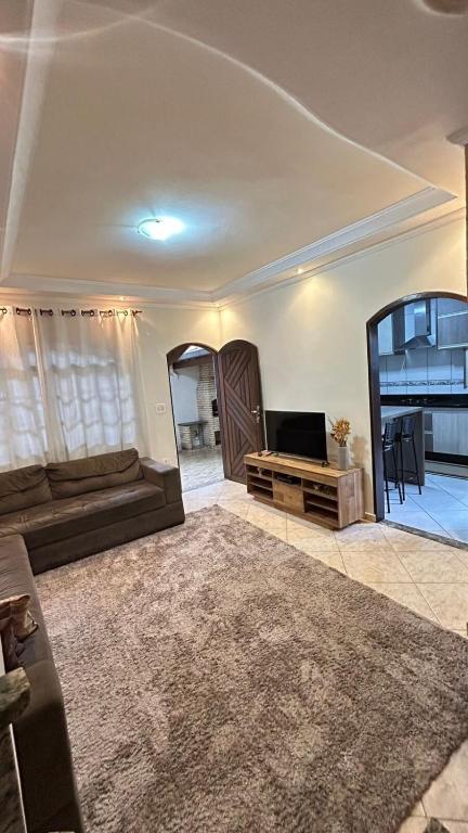 a living room with a couch and a mirror at Casa em Santo André -SP in Santo André