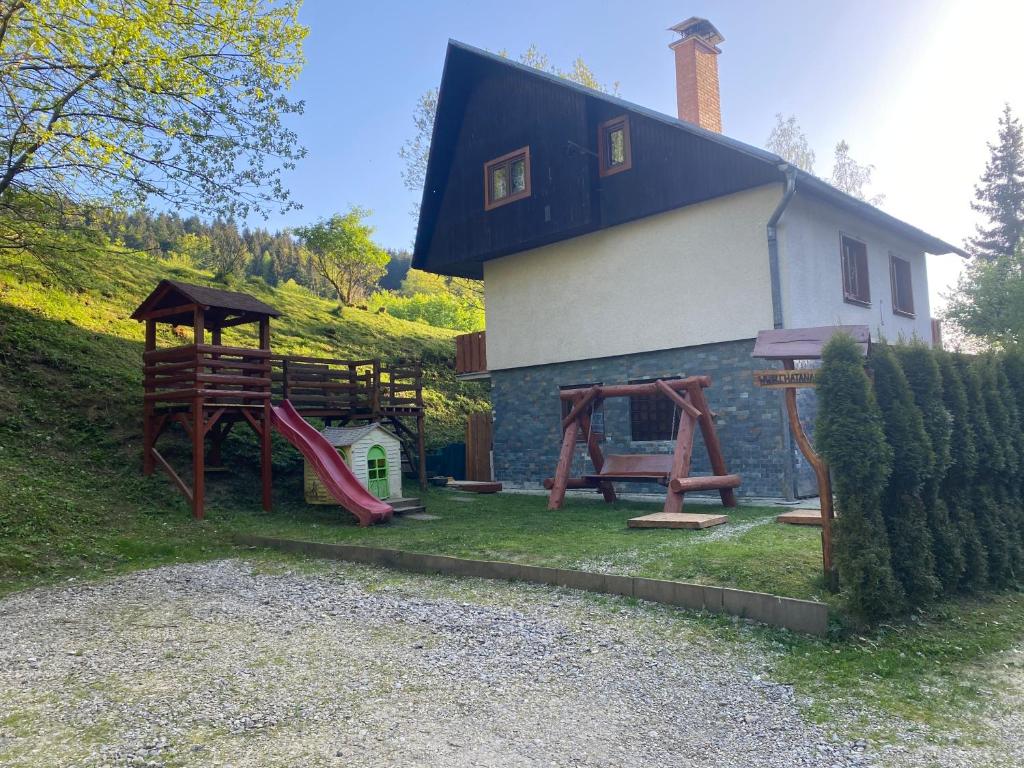 a house with a playground in front of it at Chata na Čertove in Štôla