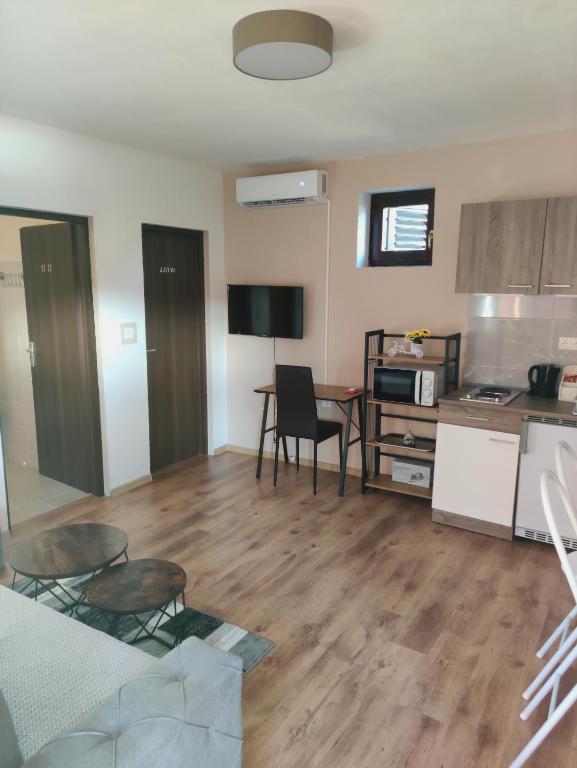 Una sala de estar con cocina y una mesa con sillas. en Apartman Lipa- Lipovac Bajakovo, en Lipovac