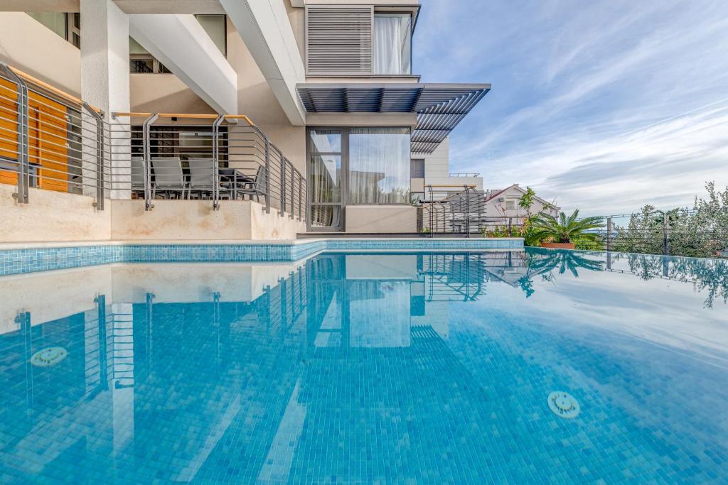 ein großes Schwimmbad vor einem Haus in der Unterkunft Villa Spectra in Makarska